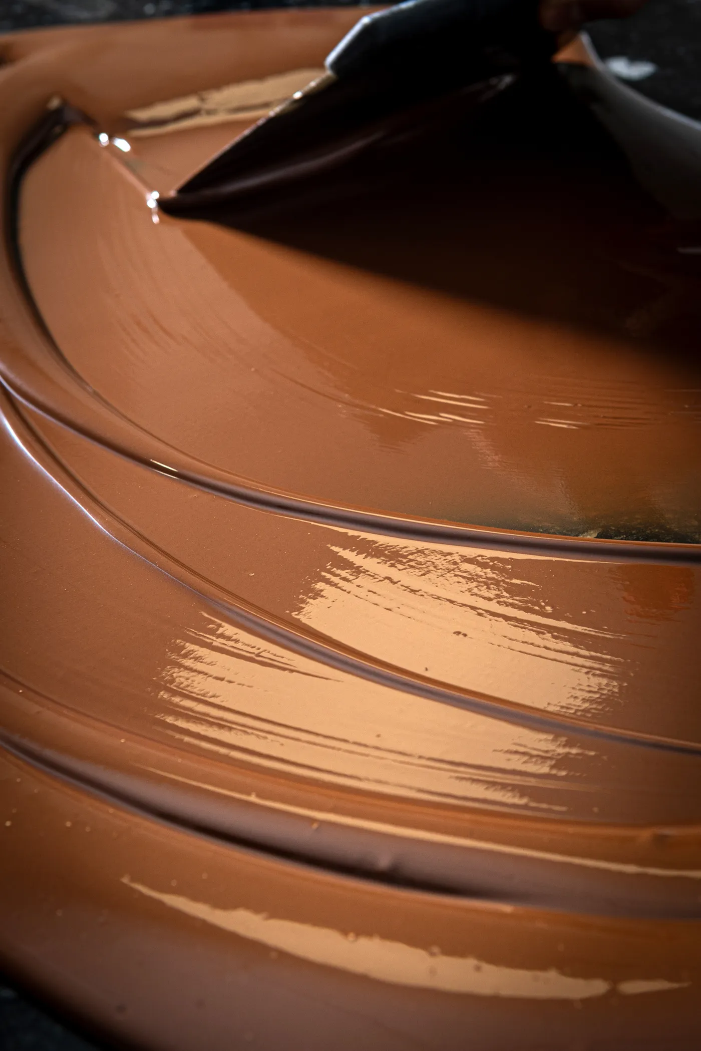 Chocolatier travaillant le chocolat tempéré à la main dans l'atelier Pure Artisan à Tours